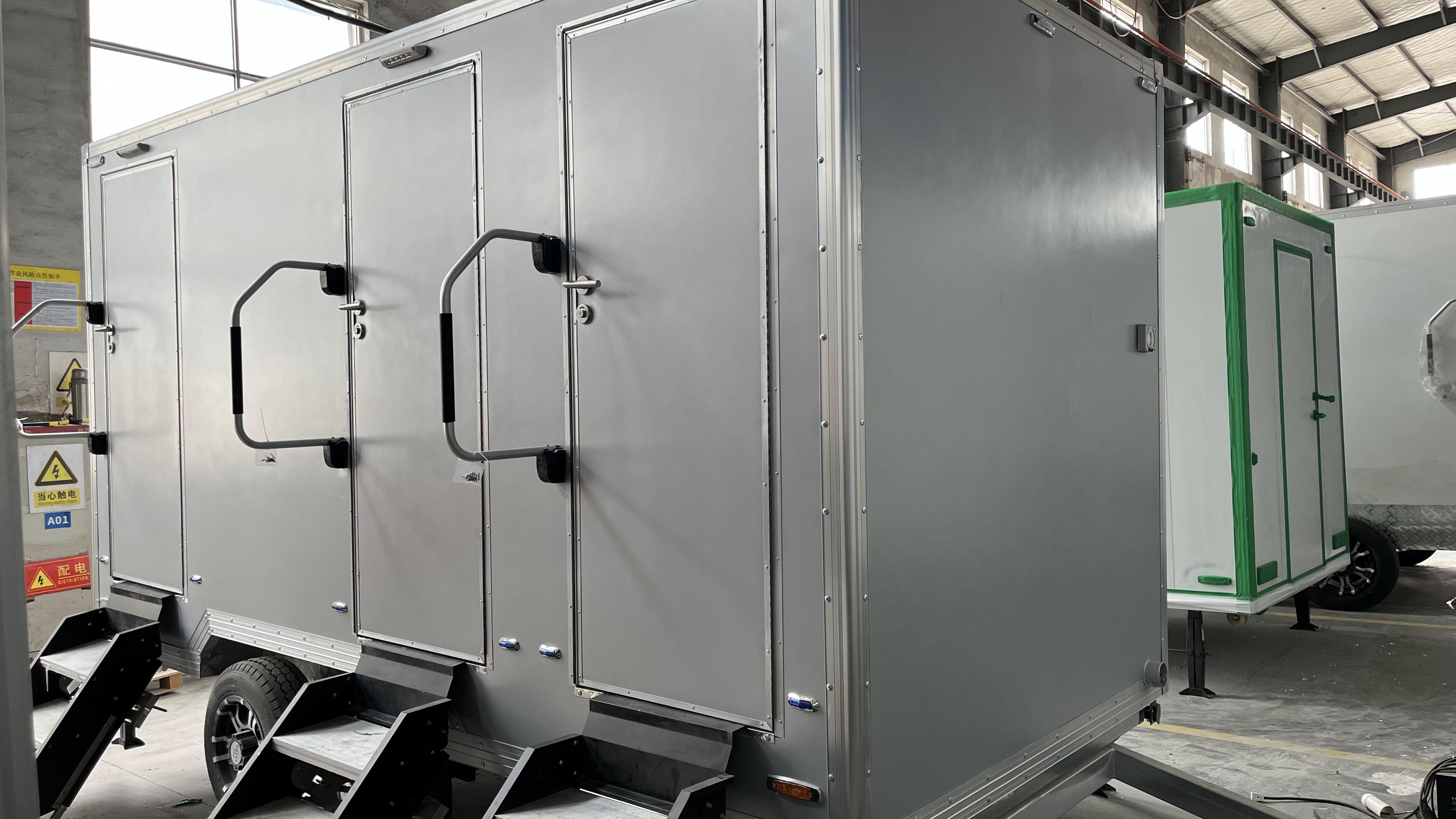Grey movable three-toilet trailer