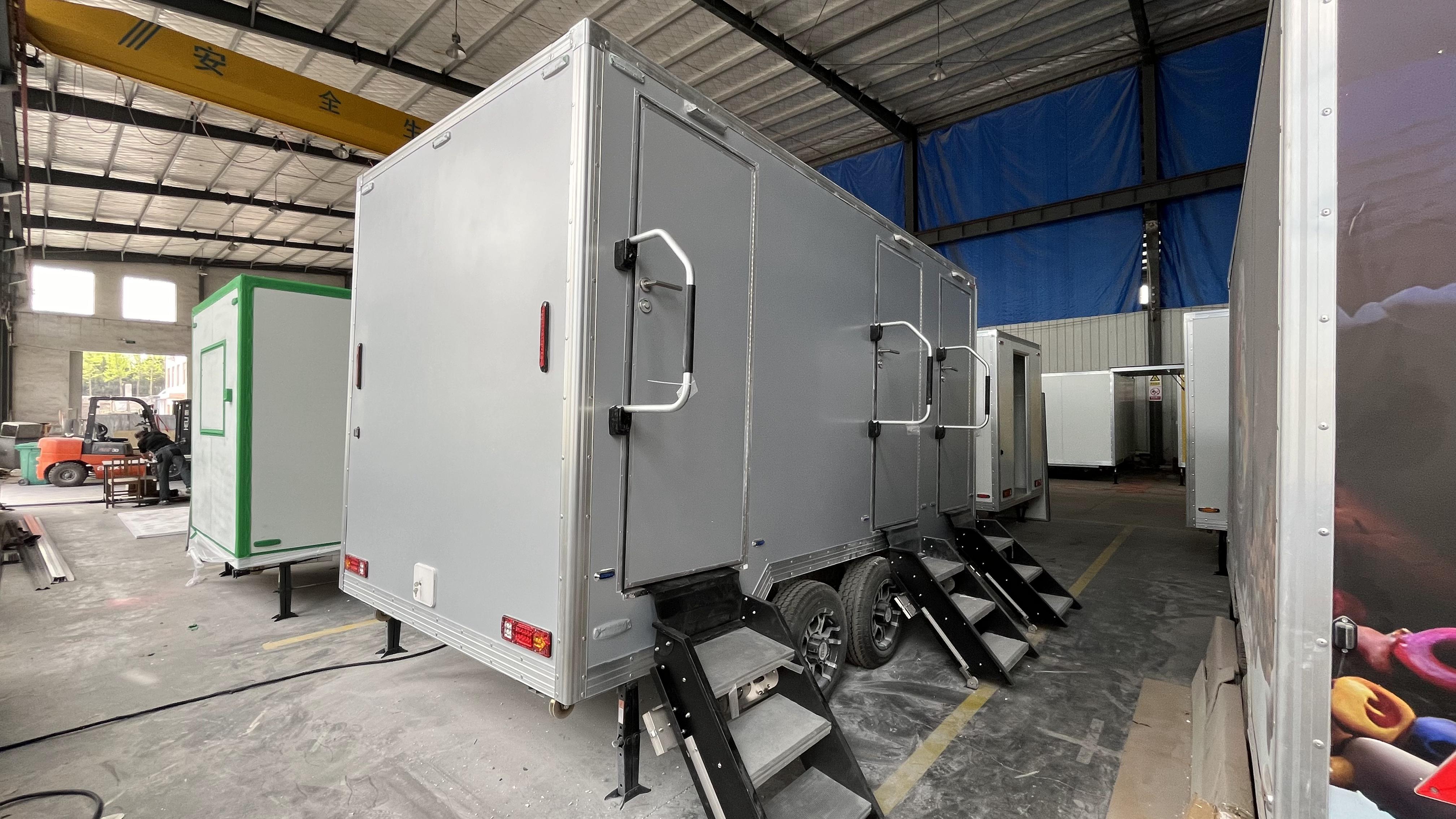Grey movable three-toilet trailer