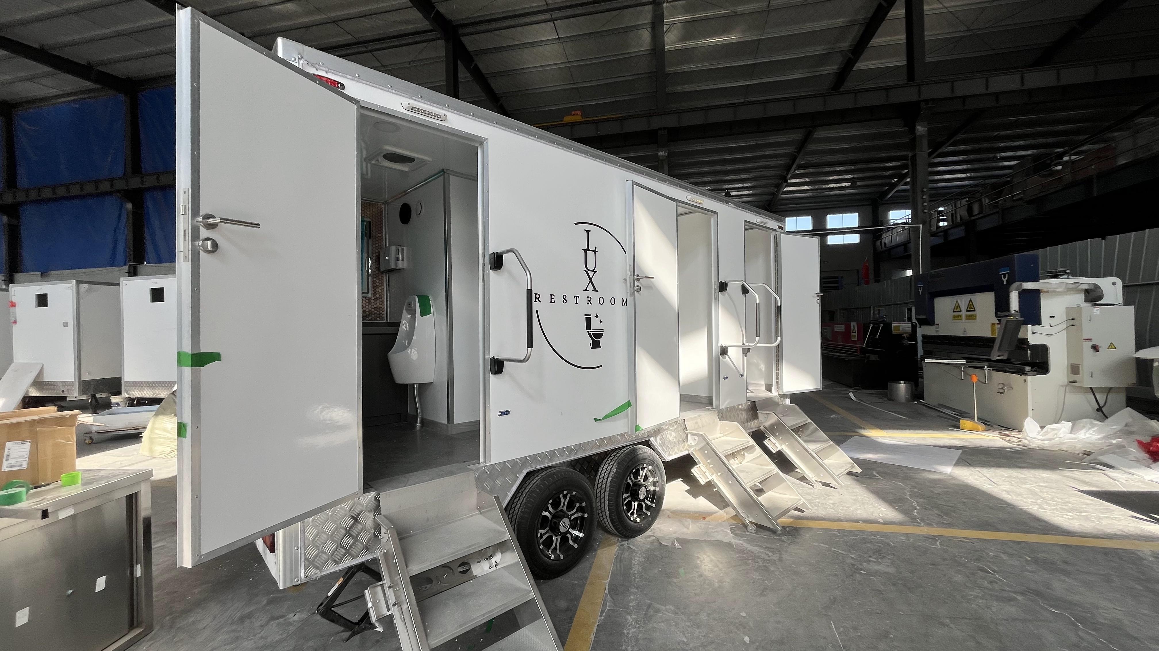 Three mobile toilet trailers with stickers, Instagram-style painted bathroom vehicles, commercial event check-in spots, and quick deployment in a towed manner