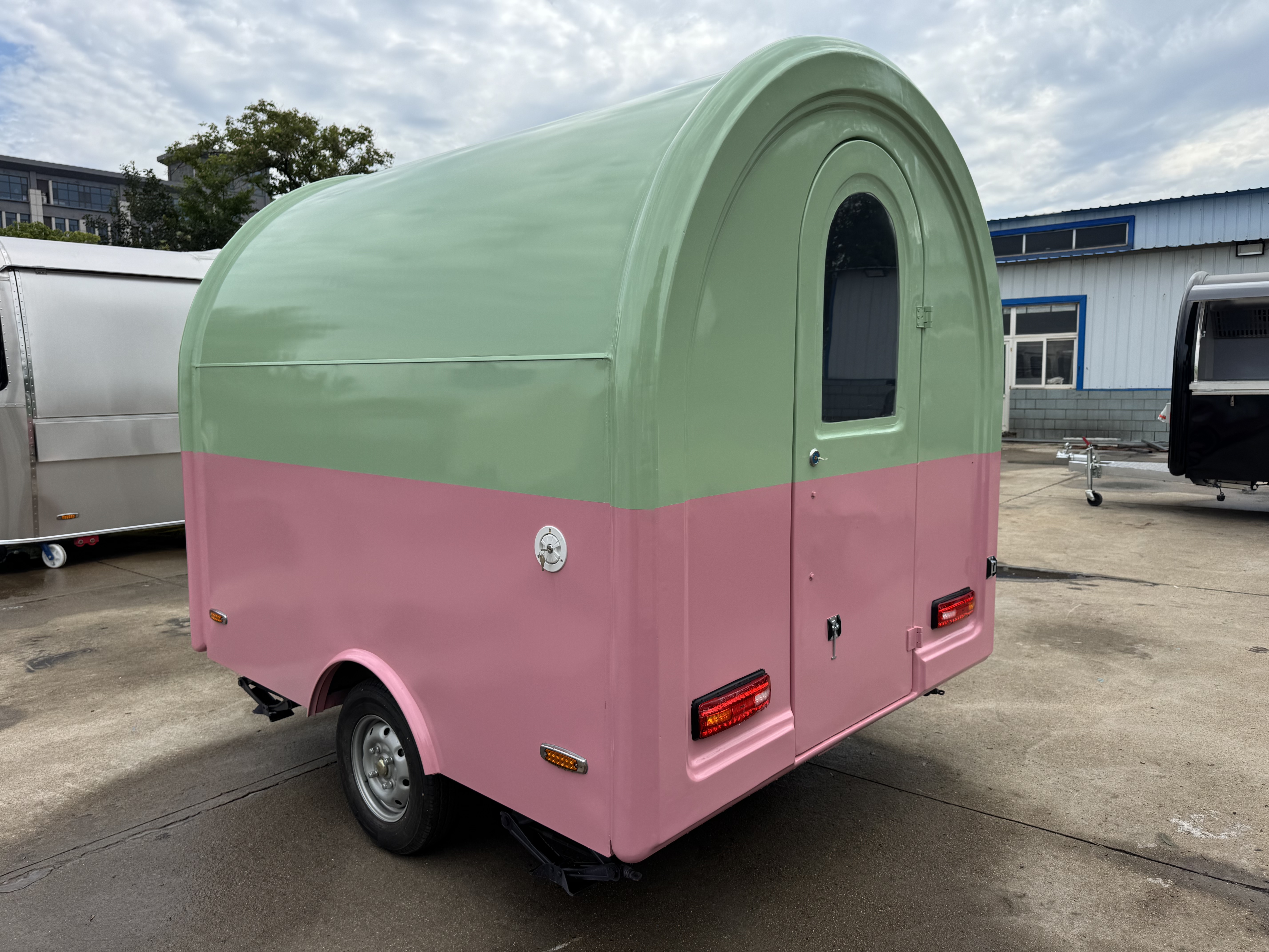 A mobile food truck with a combination of pink and green and colors, brimming with girlish charm