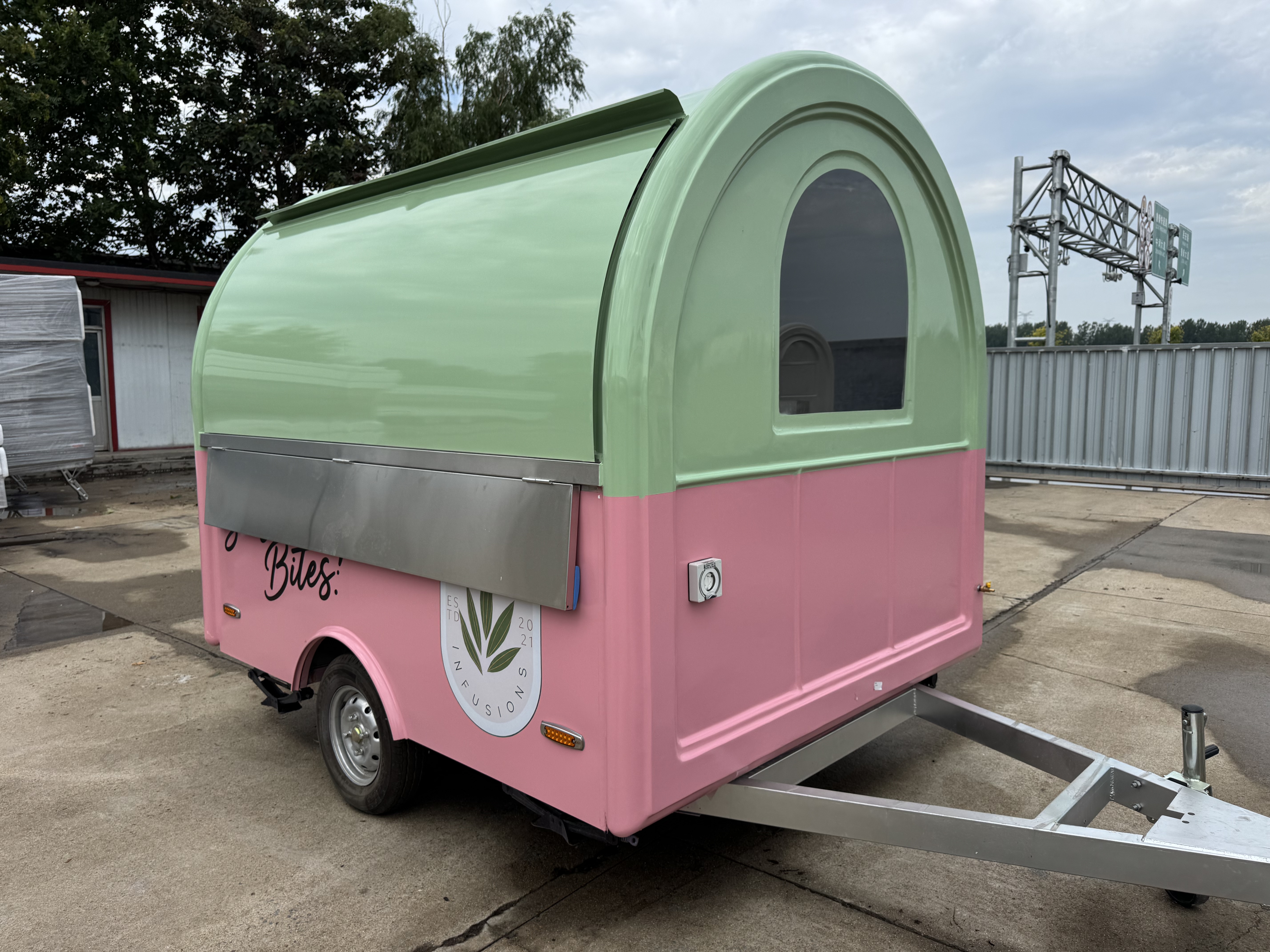 A mobile food truck with a combination of pink and green and colors, brimming with girlish charm