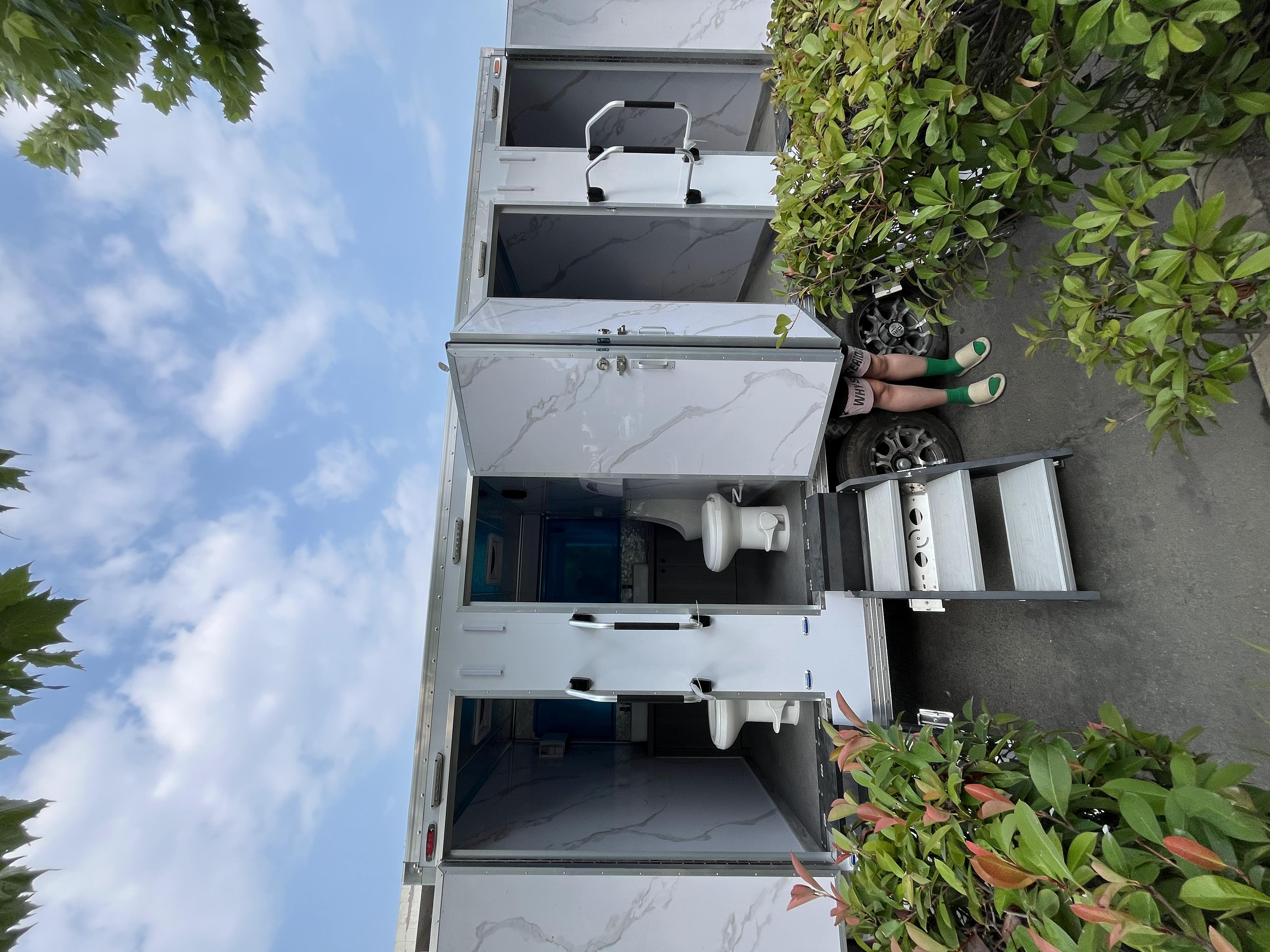White trailer four-cabin outdoor mobile toilet facilities for multiple people