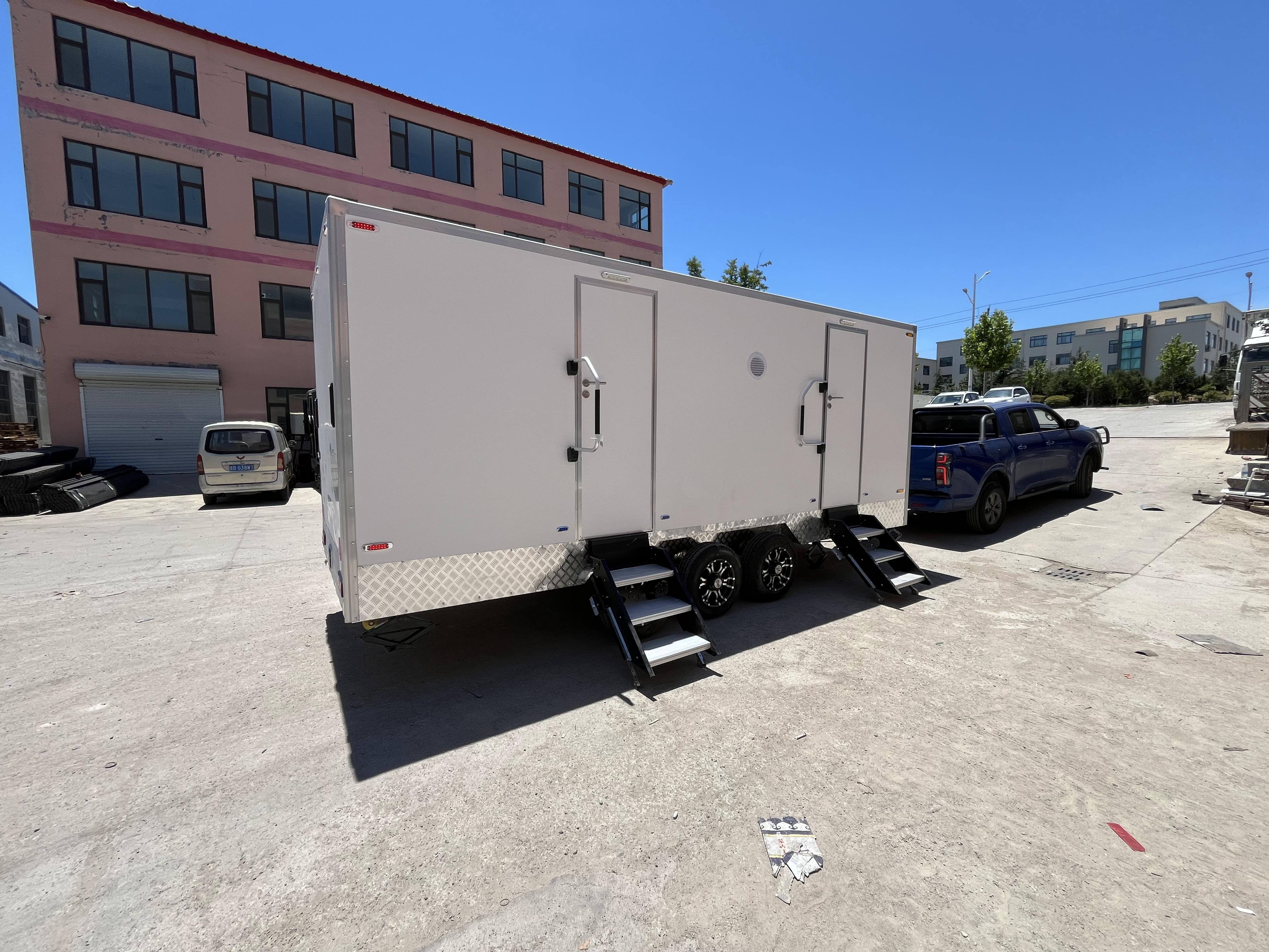 A towable double-unit mobile toilet with three wheels and steps for going up and down outdoor large venues