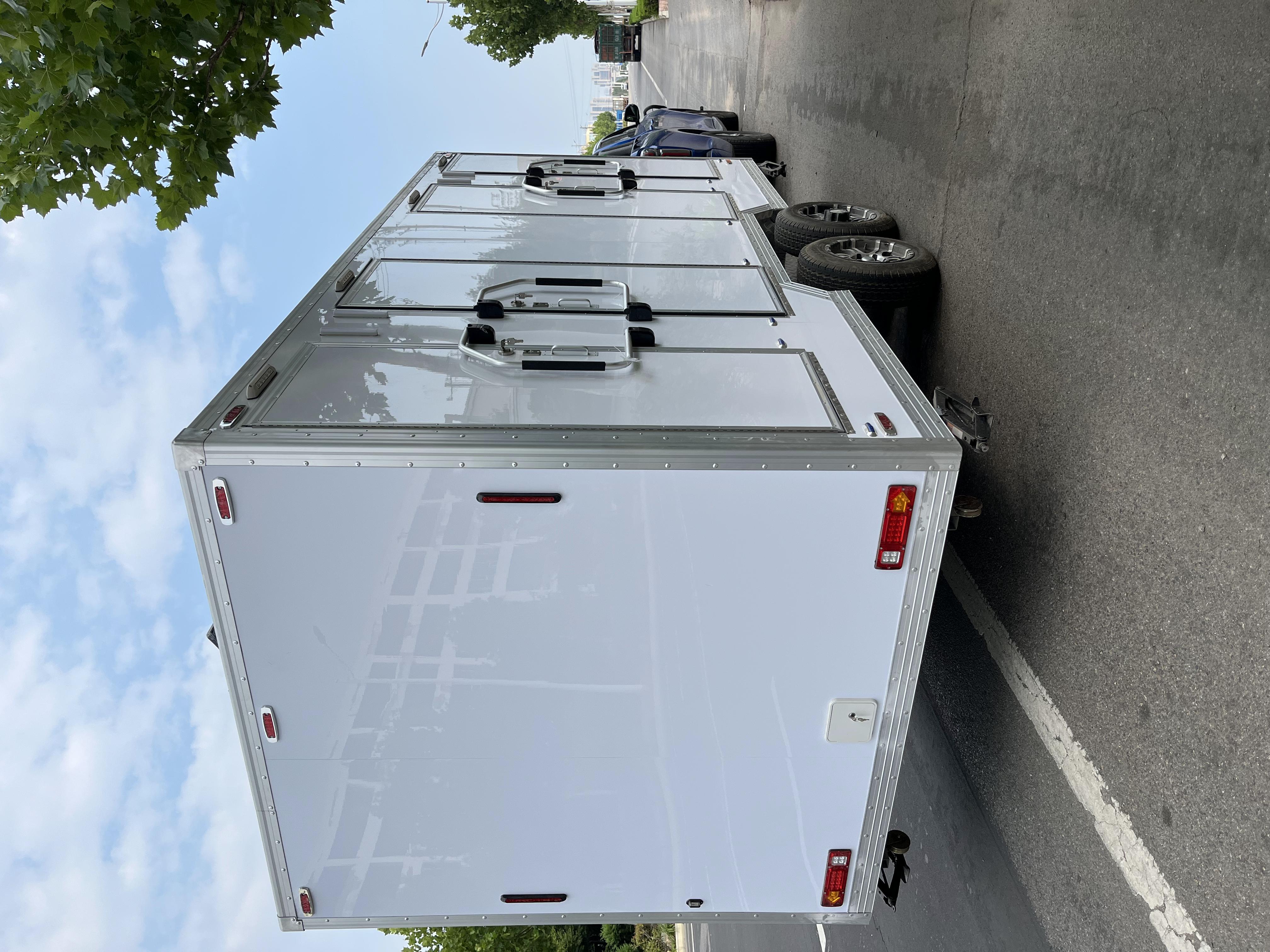 White trailer four-cabin outdoor mobile toilet facilities for multiple people