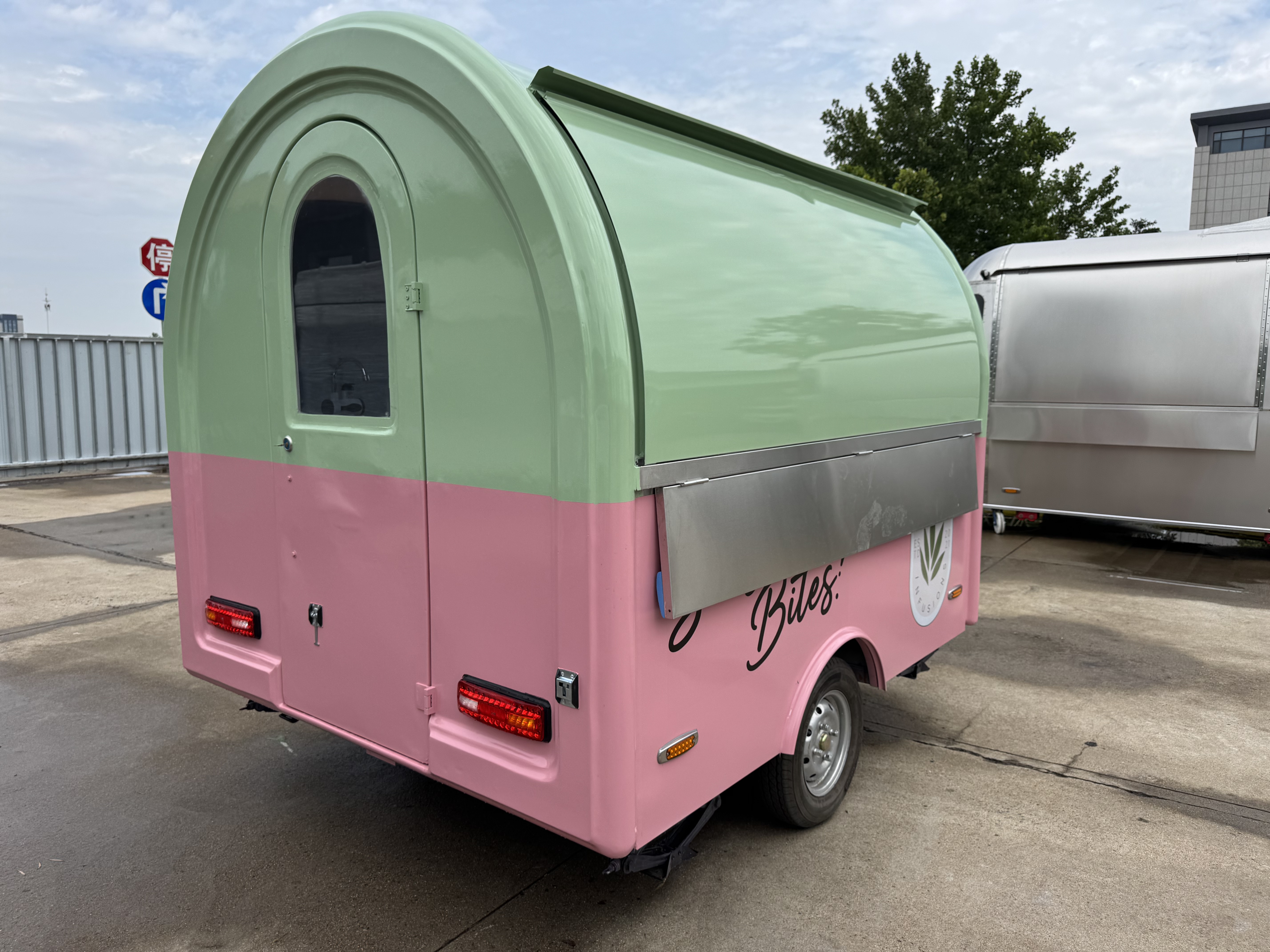 A mobile food truck with a combination of pink and green and colors, brimming with girlish charm