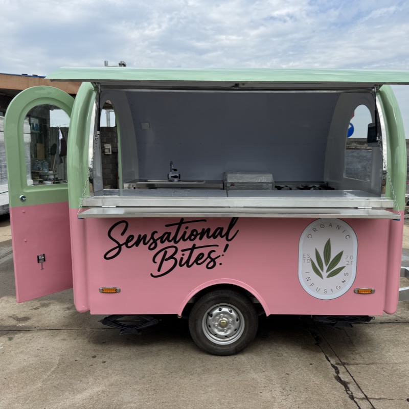 A mobile food truck with a combination of pink and green and colors, brimming with girlish charm