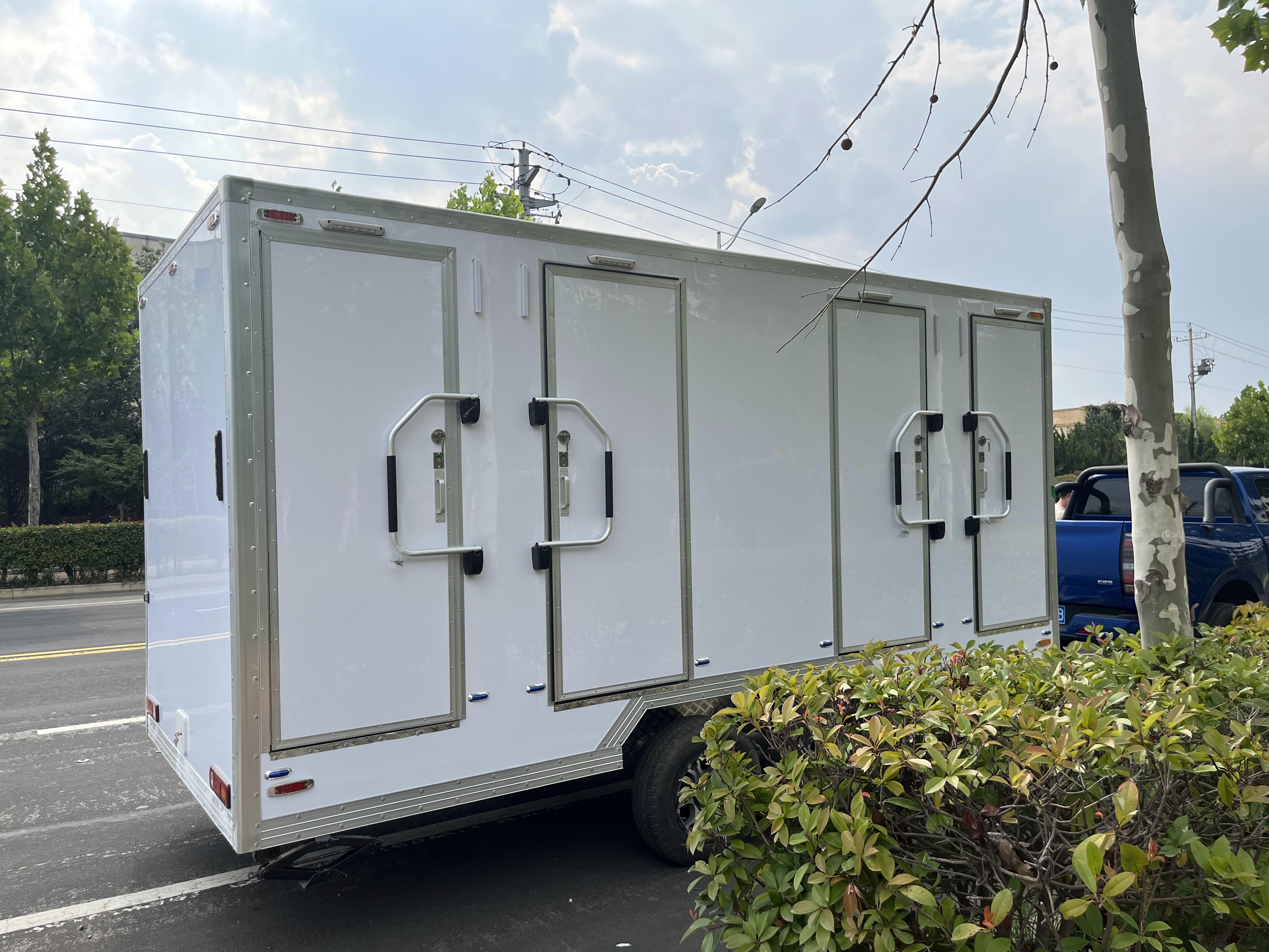 White trailer four-cabin outdoor mobile toilet facilities for multiple people