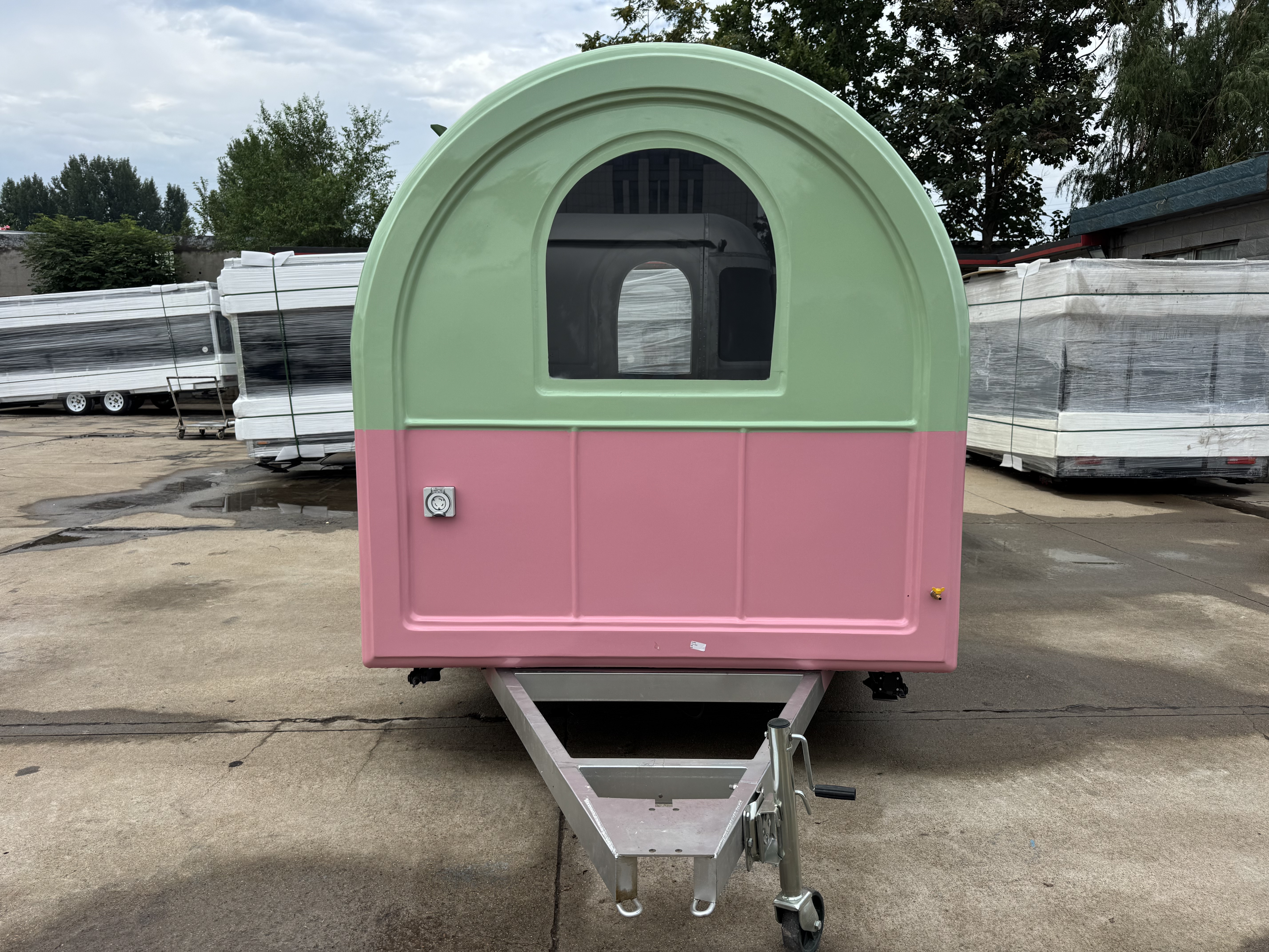A mobile food truck with a combination of pink and green and colors, brimming with girlish charm