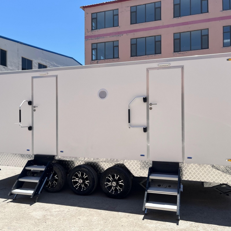 A towable double-unit mobile toilet with three wheels and steps for going up and down outdoor large venues