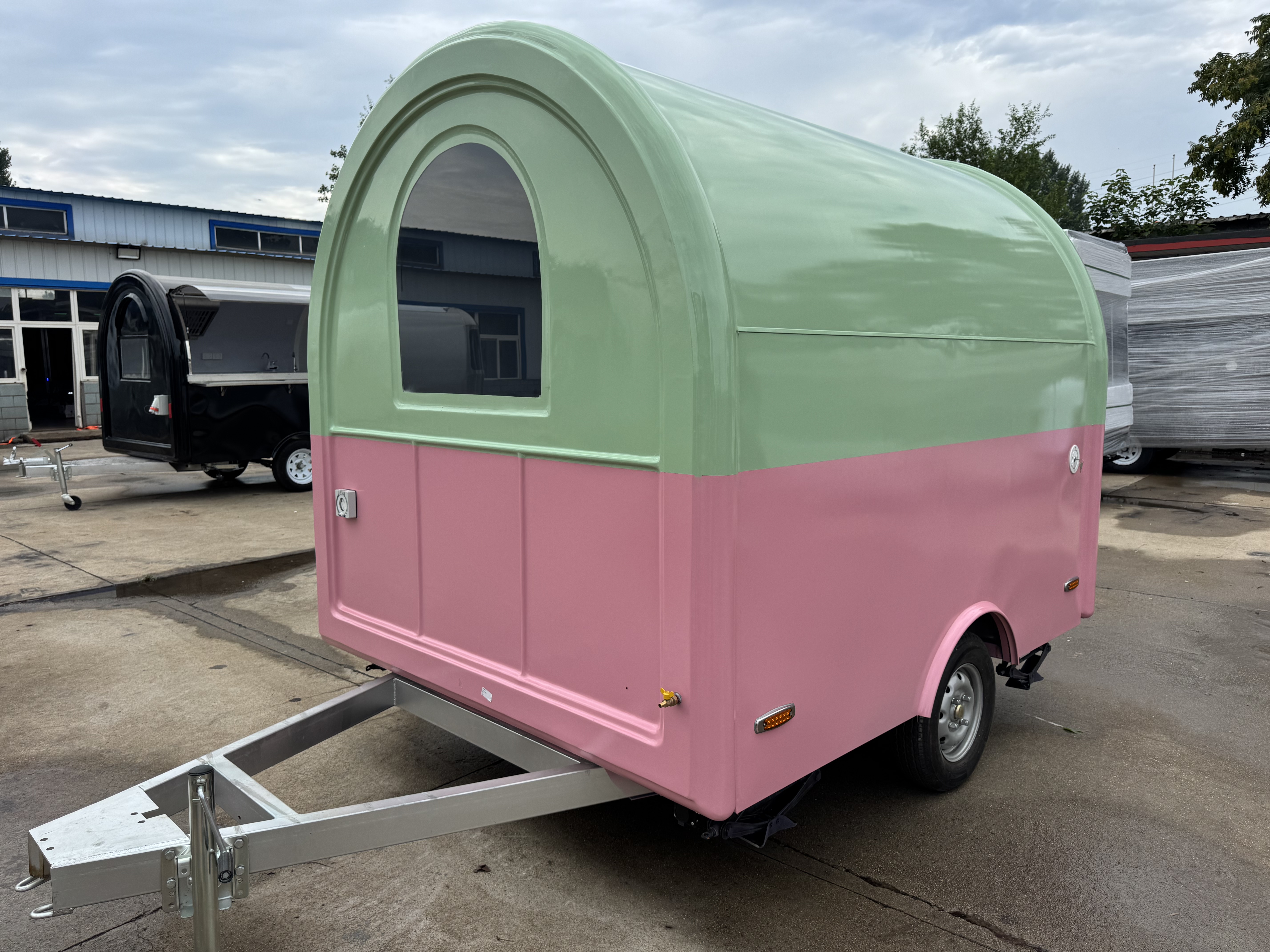 A mobile food truck with a combination of pink and green and colors, brimming with girlish charm