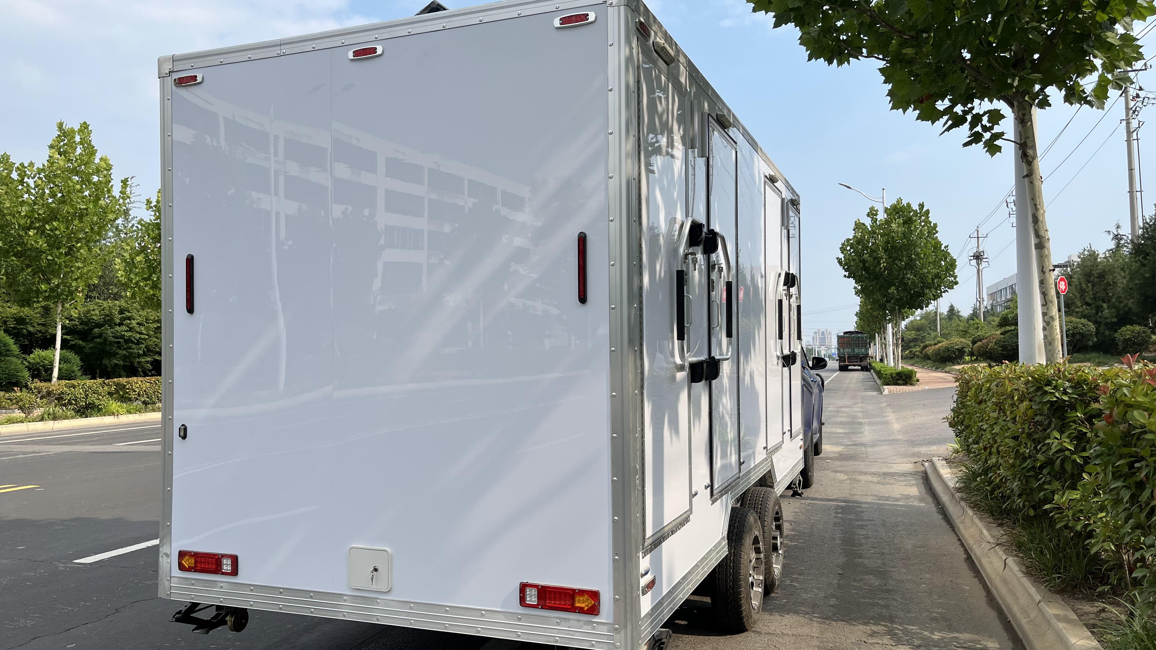 White trailer four-cabin outdoor mobile toilet facilities for multiple people