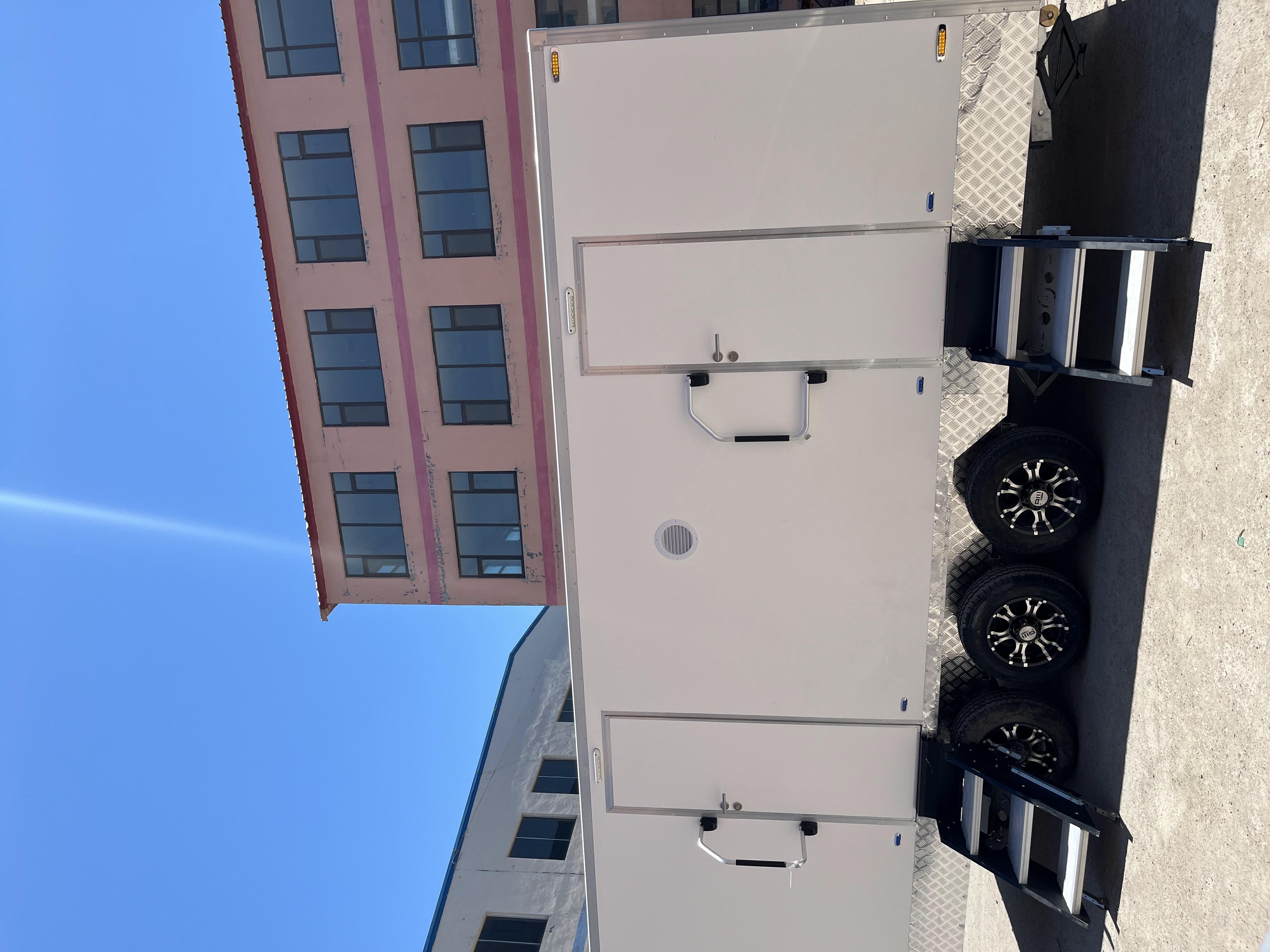 A towable double-unit mobile toilet with three wheels and steps for going up and down outdoor large venues