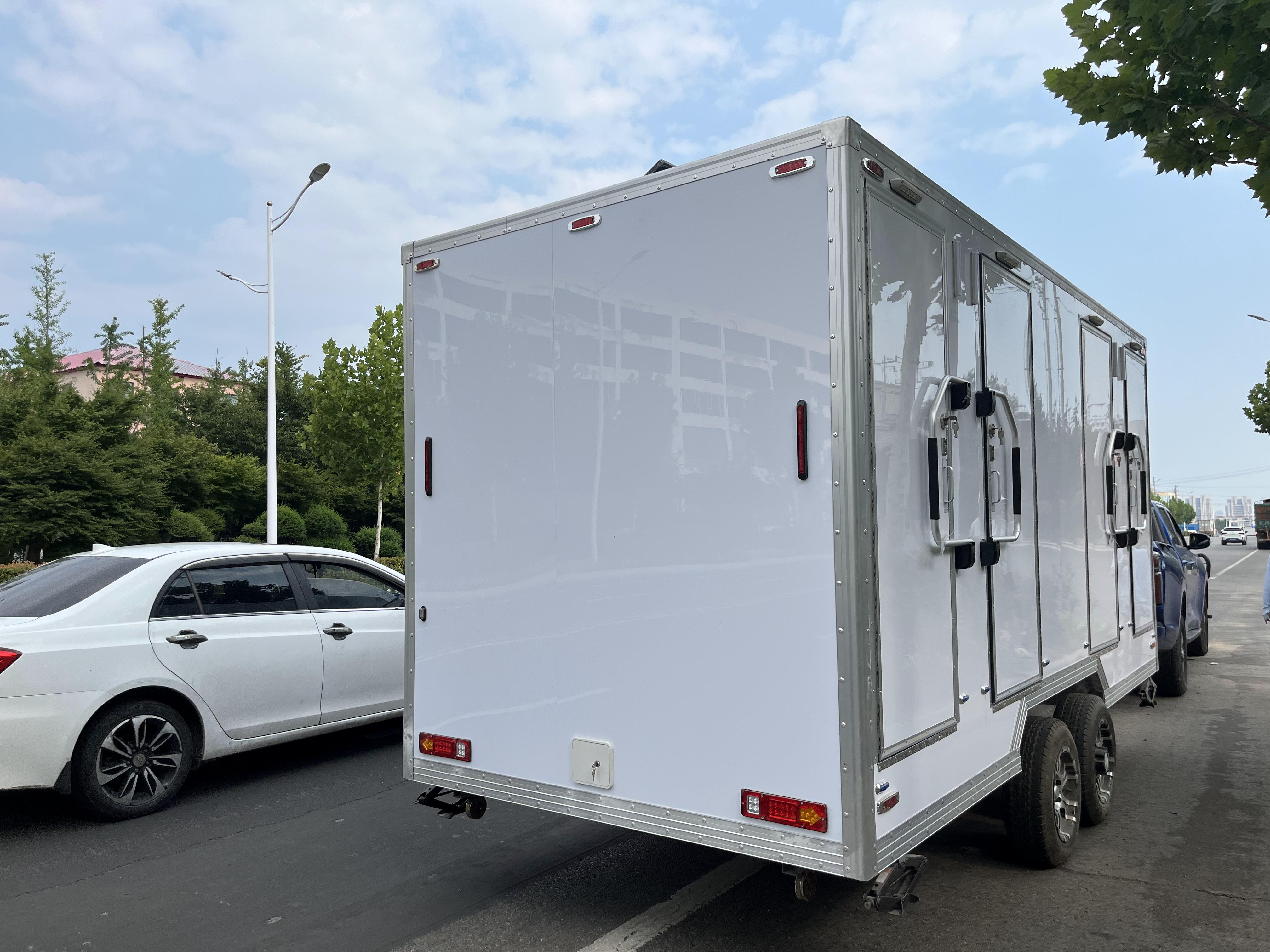 White trailer four-cabin outdoor mobile toilet facilities for multiple people