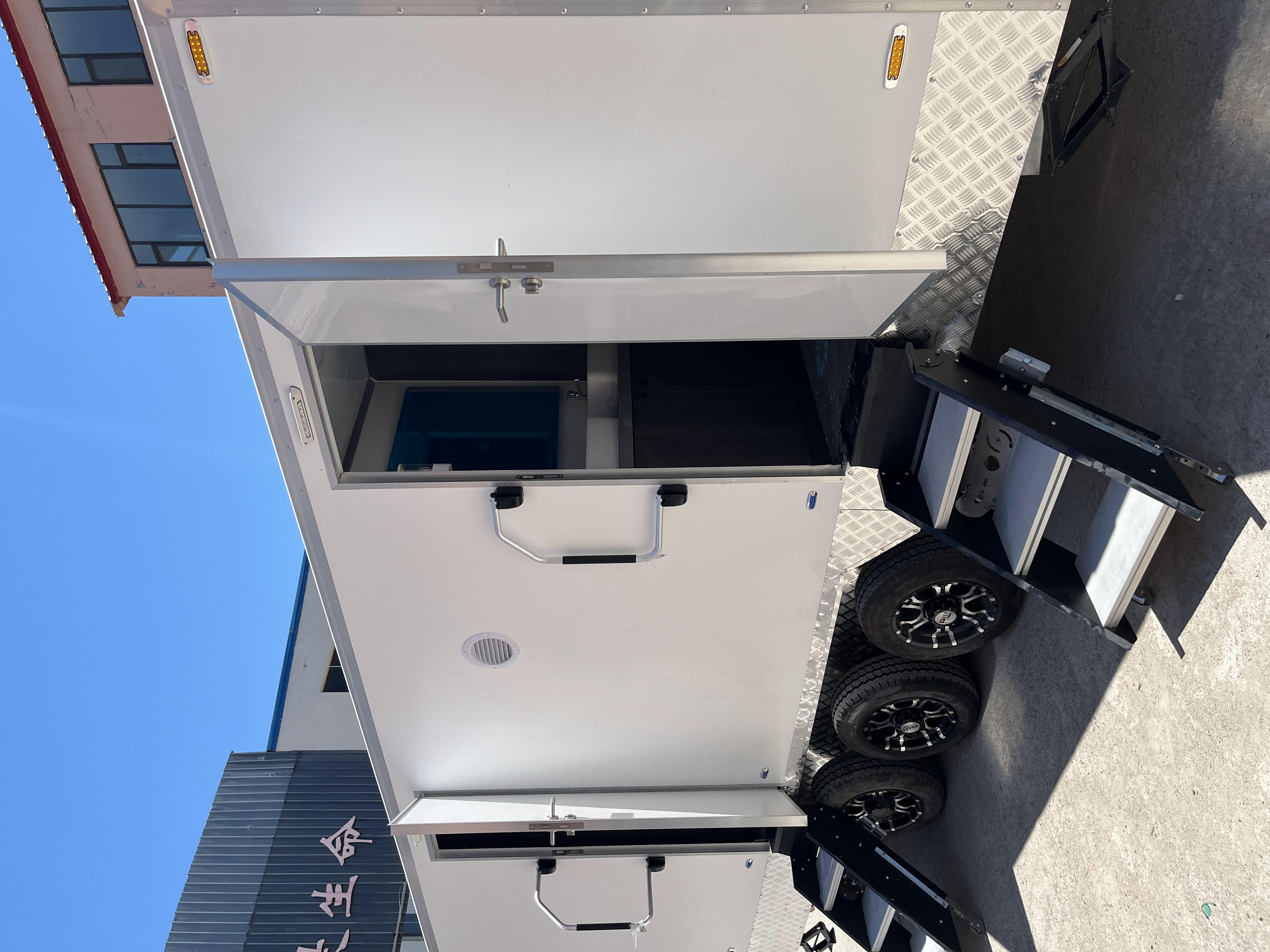 A towable double-unit mobile toilet with three wheels and steps for going up and down outdoor large venues