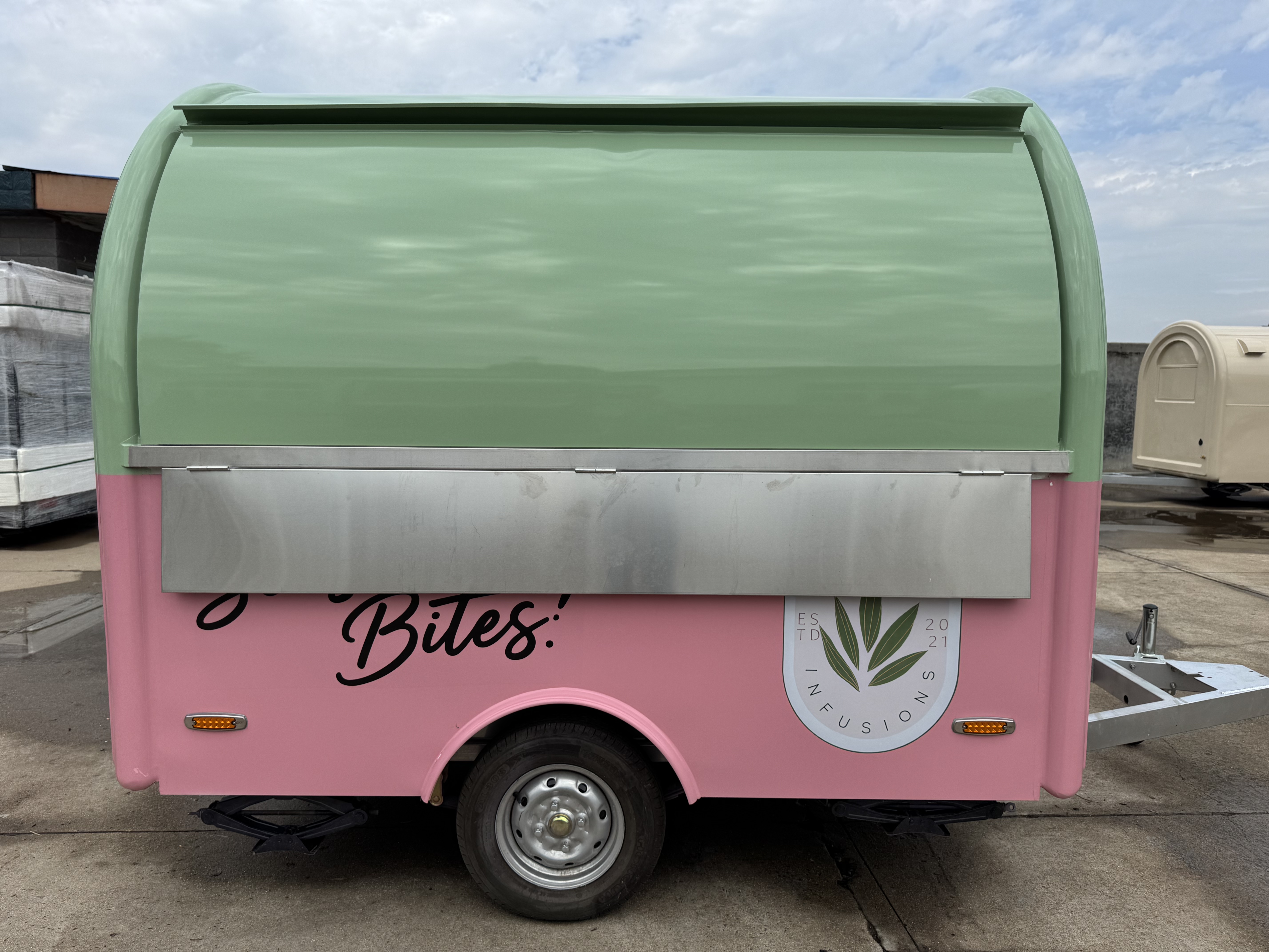 A mobile food truck with a combination of pink and green and colors, brimming with girlish charm