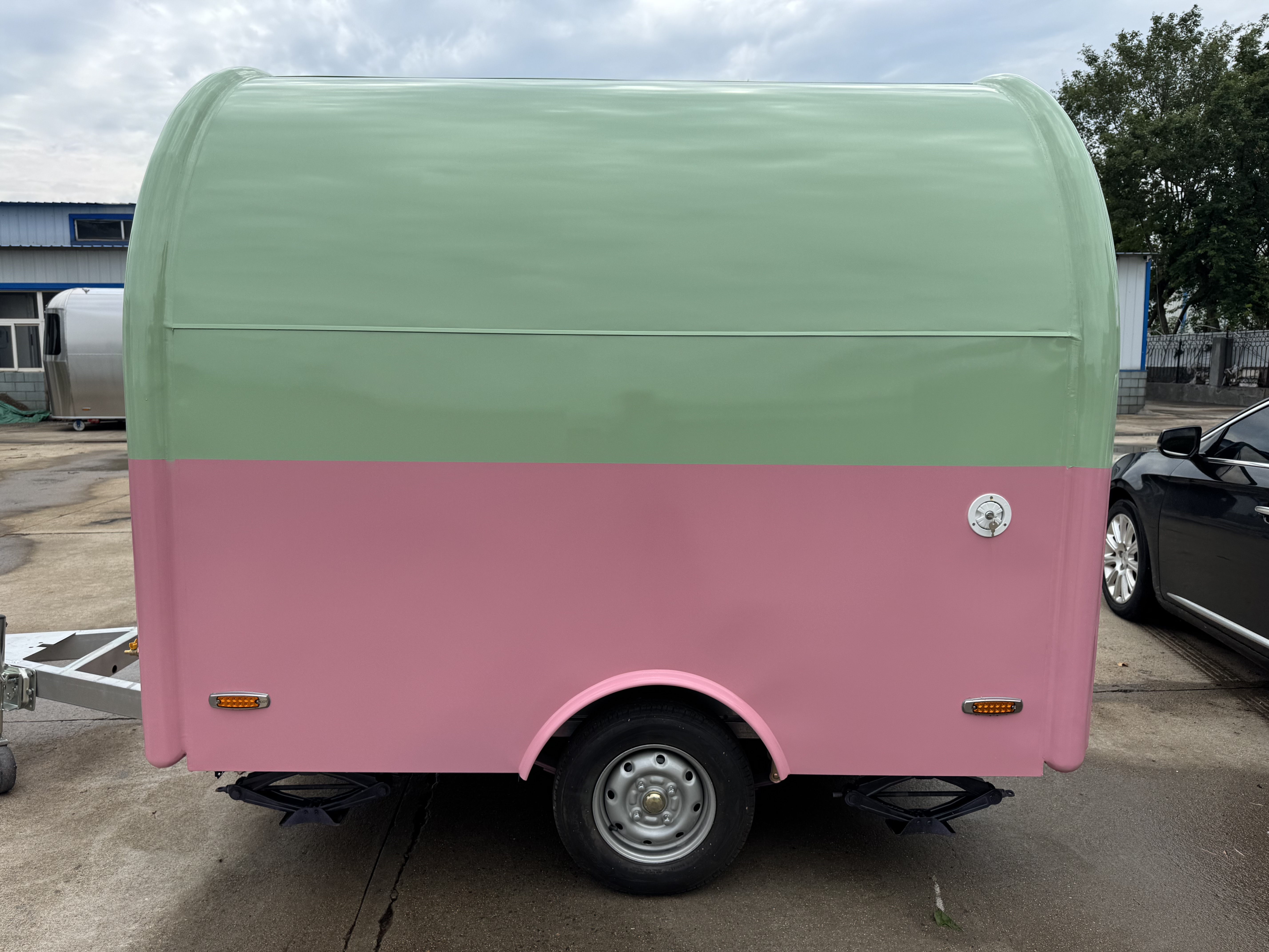 A mobile food truck with a combination of pink and green and colors, brimming with girlish charm