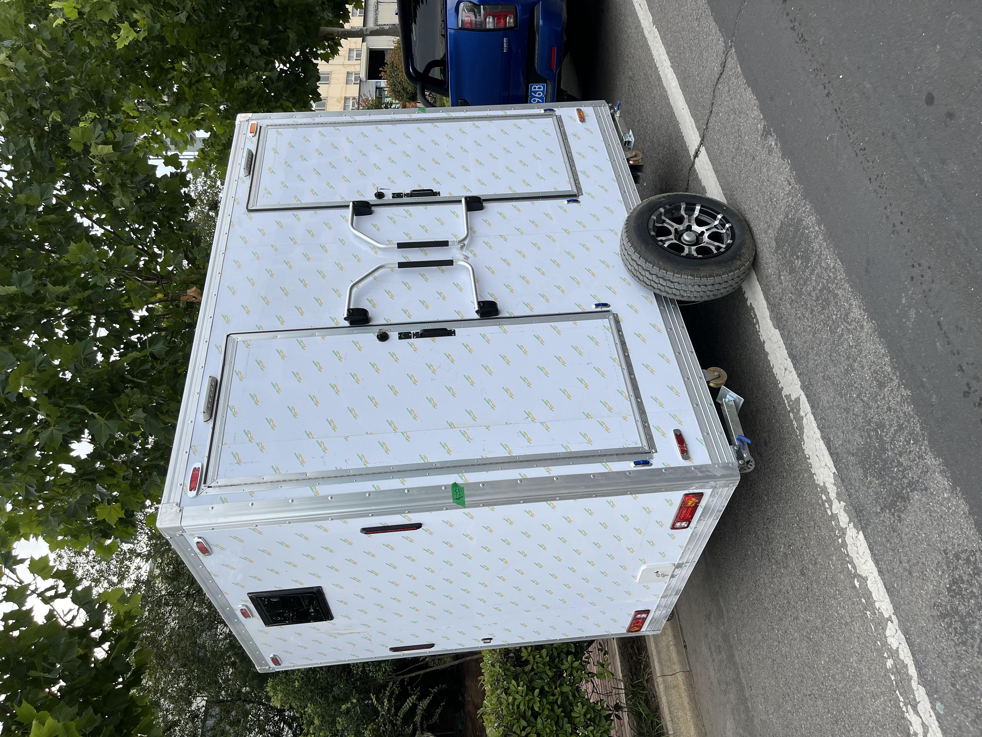 Trailer-mounted mobile double-door toilet for outdoor convenience