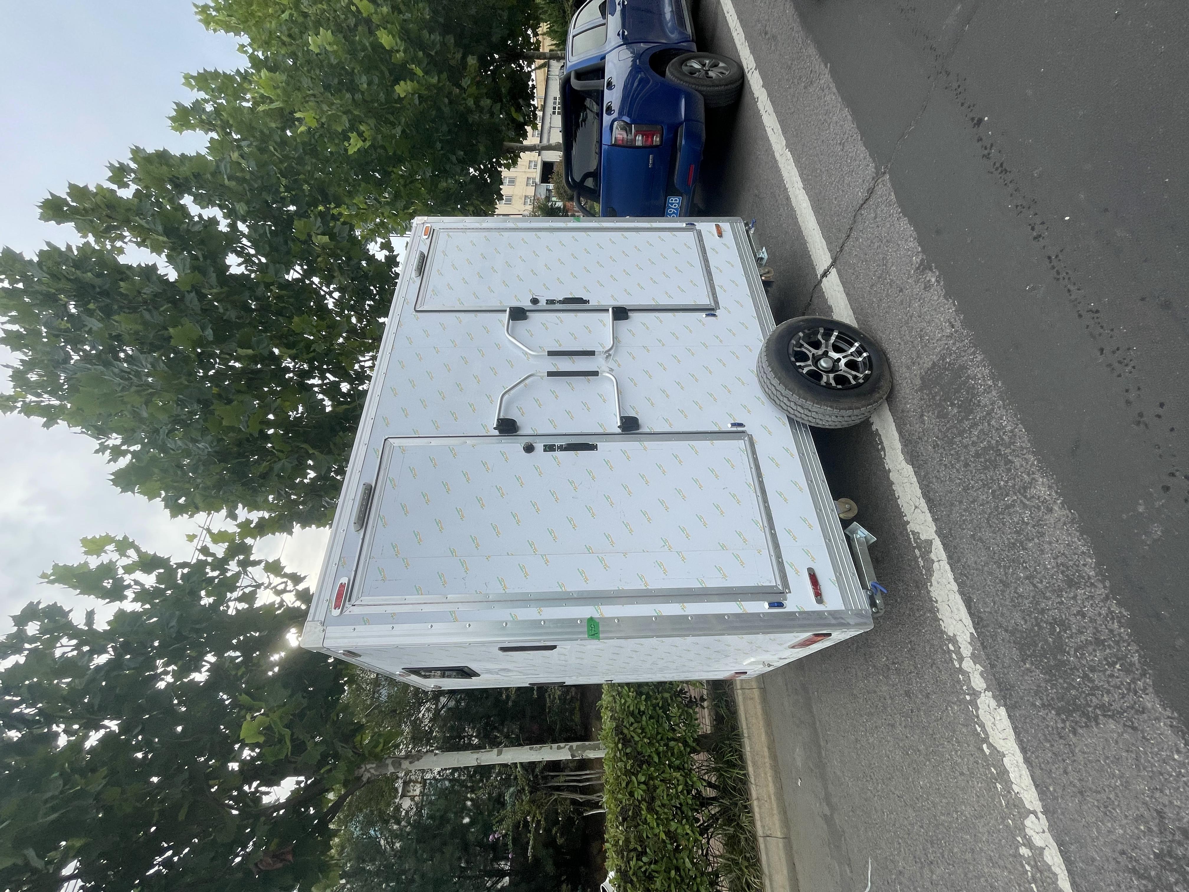 Trailer-mounted mobile double-door toilet for outdoor convenience
