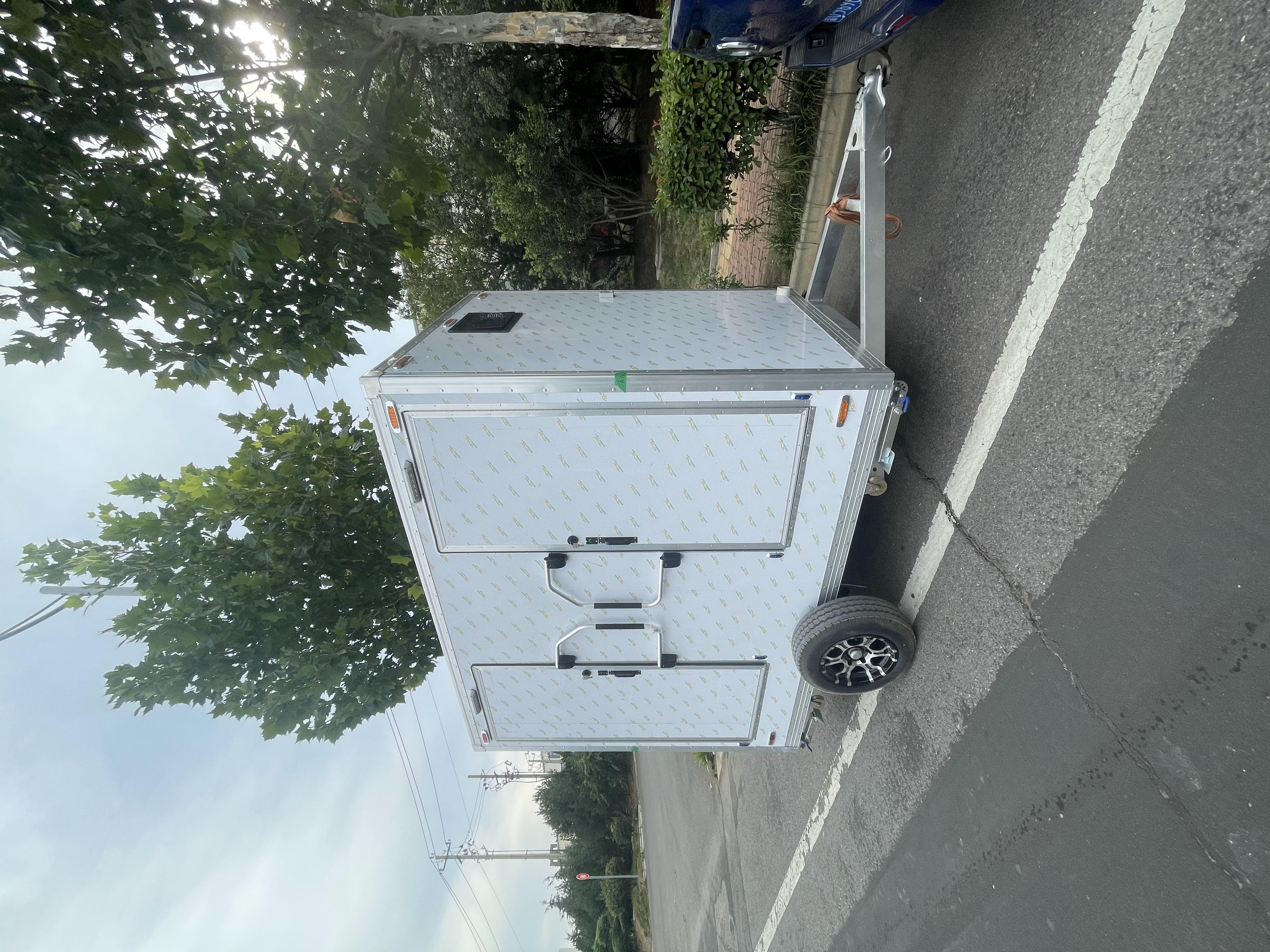 Trailer-mounted mobile double-door toilet for outdoor convenience