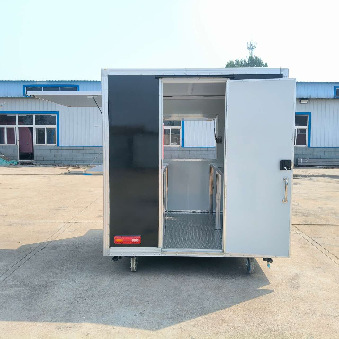 A wheeled, mobile black food truck with a window, an outdoor snack cart, and a multi-functional food truck