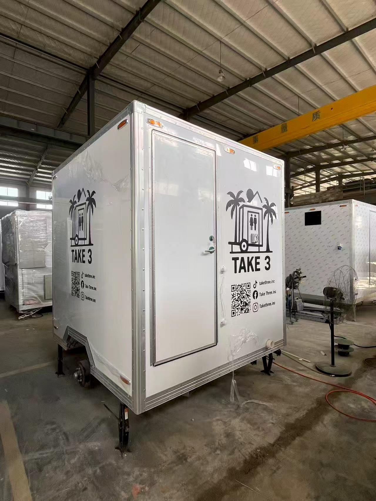A portable multi-compartment bathroom trailer with a white appearance for mobile toilets